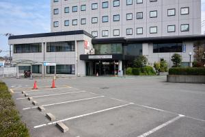ein Parkplatz vor einem großen Gebäude in der Unterkunft Hotel 1-2-3 Kurashiki in Kurashiki