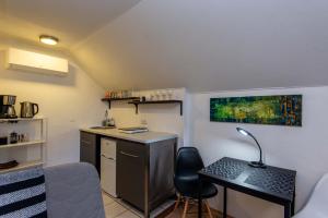 Habitación pequeña con escritorio y mesa con lámpara. en Vila Junda, en Neringa