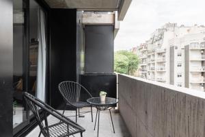 - Balcón con sillas y mesa en un edificio en Fliphaus Guateflat 'e' - 1 Bd Palermo Soho en Buenos Aires