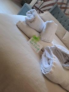 un letto con asciugamani e un cartellino con il prezzo di Maison Divino a Trani