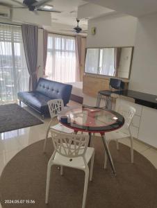 a living room with a table and chairs and a couch at Nuha Studio Stay at D'perdana Apartment in Kota Bharu
