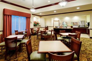 a restaurant with tables and chairs and a bar at Country Inn & Suites by Radisson, College Station, TX in College Station