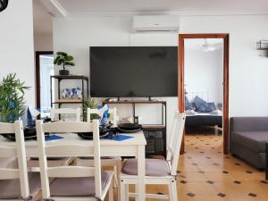 - une salle à manger avec une table, des chaises et une télévision dans l'établissement Apartamento Veracruz 200 m de la Playa, à Gandía