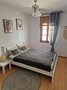 サンミゲル・デ・アボナにあるSunny Oasis Amarilla Golfのベッドと窓とラグのある寝室