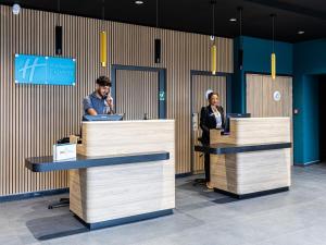 2 personnes debout sur les pupitres de réception dans un bureau dans l'établissement Holiday Inn Express Ajaccio, an IHG Hotel, à Ajaccio