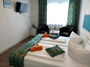 ein Hotelzimmer mit drei Betten und einer Couch in der Unterkunft Hotel Filoxenia in Butjadingen