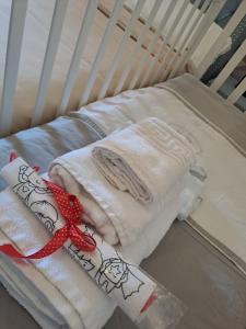 una culla ospedaliera con due asciugamani e un nastro rosso di Maison Divino a Trani