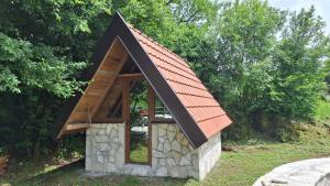 a small stone building with an orange roof at Eko selo LJUBOTINJ in Cetinje