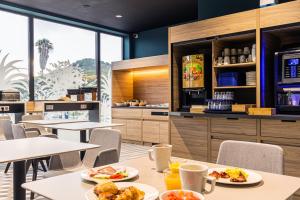 a restaurant with tables with plates of food on them at Holiday Inn Express Ajaccio by IHG in Ajaccio