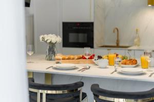 シュチルクにあるLuksusowy Apartament z wanną - Plażowa Residence Dream Apartのテーブル(皿、グラスワイン、食べ物付)