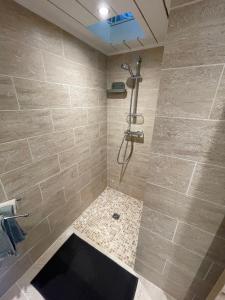 a bathroom with a shower with a tiled wall at La maison d'Eddy et Caro aux Portes du Verdon in Trigance