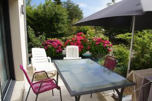 a table and chairs and an umbrella on a patio at Studio RDC Terrasse Repos en Cote d'Armor in Perros-Guirec +3 photos