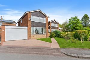 a brick house with a white garage at Woodvale Gardens in Wylam
