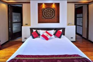 a bedroom with a white bed with red pillows at Large 4 bed villa short walk to Maenam beach in Mae Nam