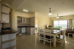 una cucina e una sala da pranzo con tavolo e sedie di Saints View Resort Unit 22 a Uvongo Beach