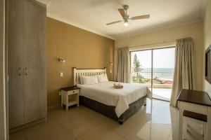 a bedroom with a bed with a view of the ocean at Saints View Resort Unit 22 in Uvongo Beach +15 photos