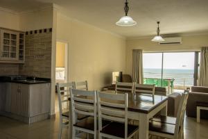 una cucina e una sala da pranzo con tavolo e sedie di Saints View Resort Unit 22 a Uvongo Beach