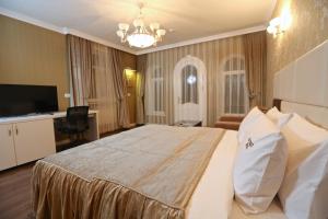 een hotelkamer met een groot bed en een televisie bij Old Street Boutique Hotel in Baku