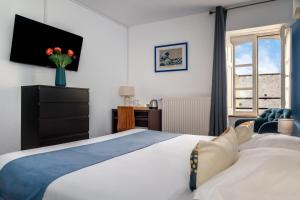 a bedroom with a large bed and a window at Hotel Elizabeth - Intra Muros in Saint Malo