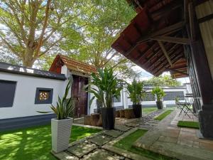 un patio de una casa con árboles y plantas en The Syawal, en Johor Bahru