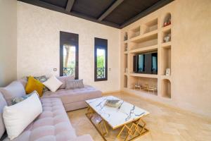 a living room with a couch and a table at Villa Riad Mamouni - piscine privée et jacuzzi in Marrakech