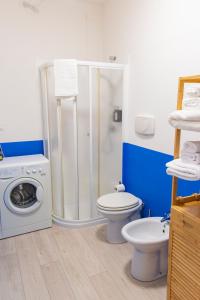 a bathroom with a shower and a toilet and a washing machine at InLoco Beach in Fano