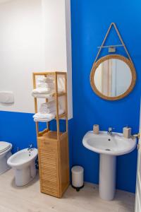 a blue bathroom with a sink and a mirror at InLoco Beach in Fano