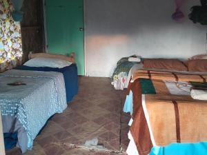 sypialnia z 2 łóżkami i podłogą wyłożoną kafelkami w obiekcie Yasur View Bungalow and Tree House w mieście White Sands