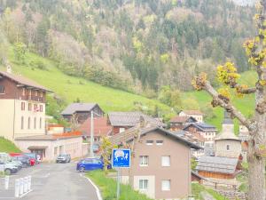 a village with cars parked on the side of a mountain at Auberge le bois du cornet in La Forclaz