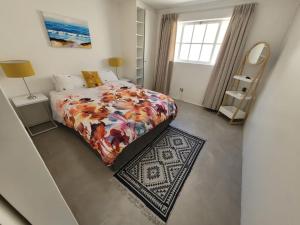 a small bedroom with a bed and a rug at LA HACIENDA - MODERN, BRIGHT, STYLISH House with Private Pool in Cape Town +19 photos