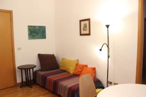 un sofá con almohadas coloridas sentado en una habitación en Navigli, en Milán