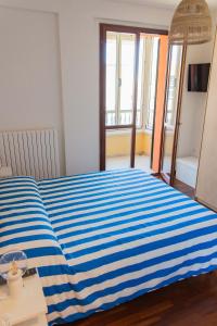 a blue and white striped bed in a room at InLoco Beach in Fano