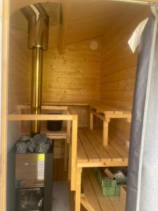 una pequeña sauna de madera con estufa. en Niiralan Tila : Skyview Cabin, en Pahajoki