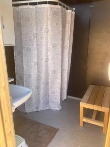 a bathroom with a shower curtain and a sink at Niiralan Tila : Skyview Cabin in Pahajoki