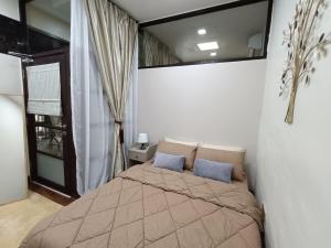 1 dormitorio con 1 cama con 2 almohadas azules en The Syawal, en Johor Bahru