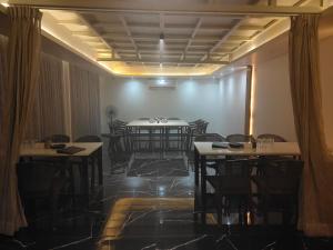 jadalnia ze stołami, krzesłami i światłami w obiekcie Hotel Regency, Akola w mieście Akola