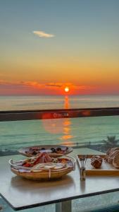 a table with two plates of food and a sunset at Ulu Panorama Residence in Alanya