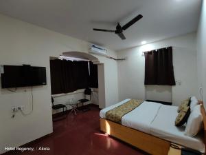 sypialnia z łóżkiem i telewizorem z płaskim ekranem w obiekcie Hotel Regency, Akola w mieście Akola