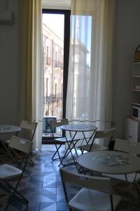 a room with tables and chairs and a window at Il Teatro Rooms in Catania