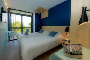 カリー・ル・ルエにあるVillage Club Miléade Carry-le-Rouetの青い壁のベッドルーム1室(大きな白いベッド1台付)