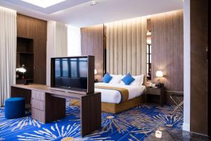 Habitación de hotel con cama y TV de pantalla plana. en Novo Hotel en Riad