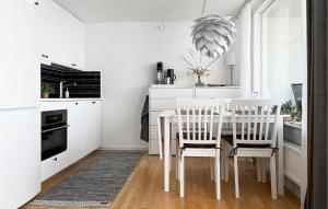 een witte keuken met een witte tafel en stoelen bij Nice Apartment In Visby With Wifi in Visby