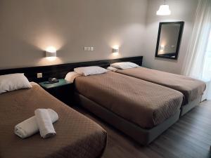 Plaza Hotel في أليكساندروبولي: غرفة فندقية بسريرين ومرآة