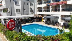 uma piscina em frente a um hotel com um restaurante em Moni Hotel em Marmaris