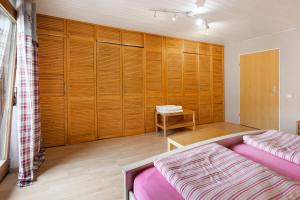 1 dormitorio con 1 cama y pared de madera en Haus am Südhang, en Lenzkirch