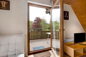 een woonkamer met een glazen schuifdeur naar een balkon bij Haus am Südhang in Lenzkirch