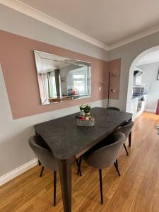 a dining room table with chairs and a mirror at Garden Place in Clevedon
