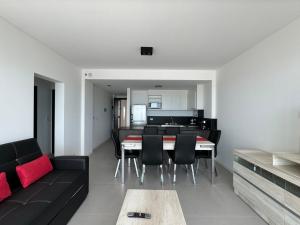 a living room with a black couch and a table at Edificio Grimm in Puerto Madryn