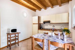 Una cocina con una mesa y sillas en una habitación. en Bilo Garden Agriturismo Teboi, en Lazise