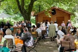 a group of people sitting at tables in front of a cabin at Landhotel Krummenweg in Ratingen